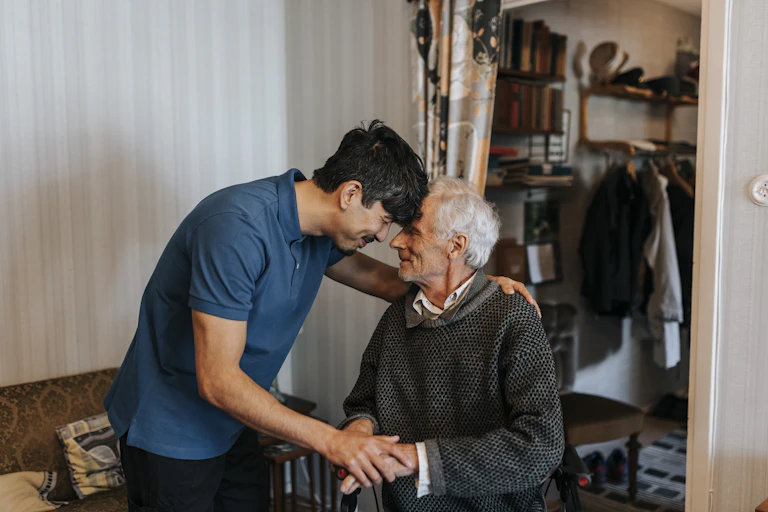A man touches foreheads with his elderly relative