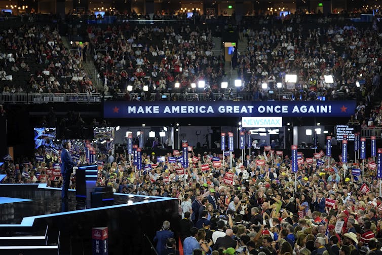 Florida Gov. Ron DeSantis standing on stage in front of a crowd of thousands