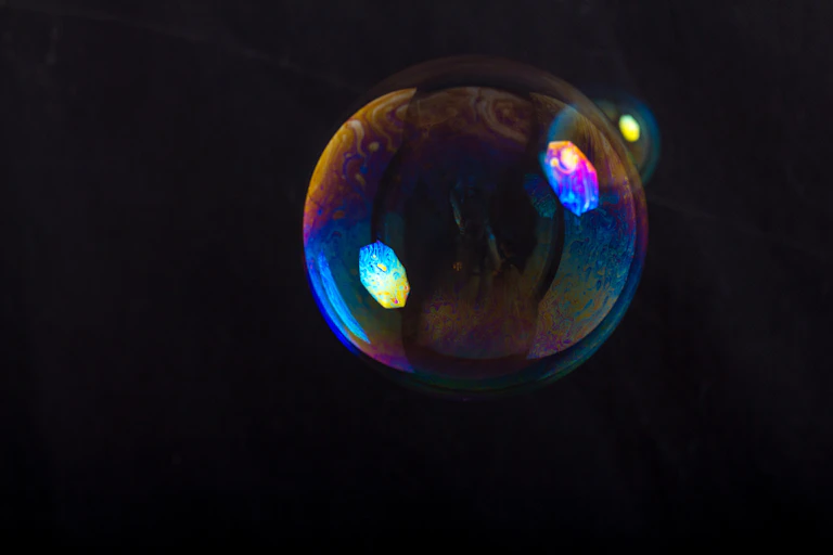 Close up of soap bubble against black background.