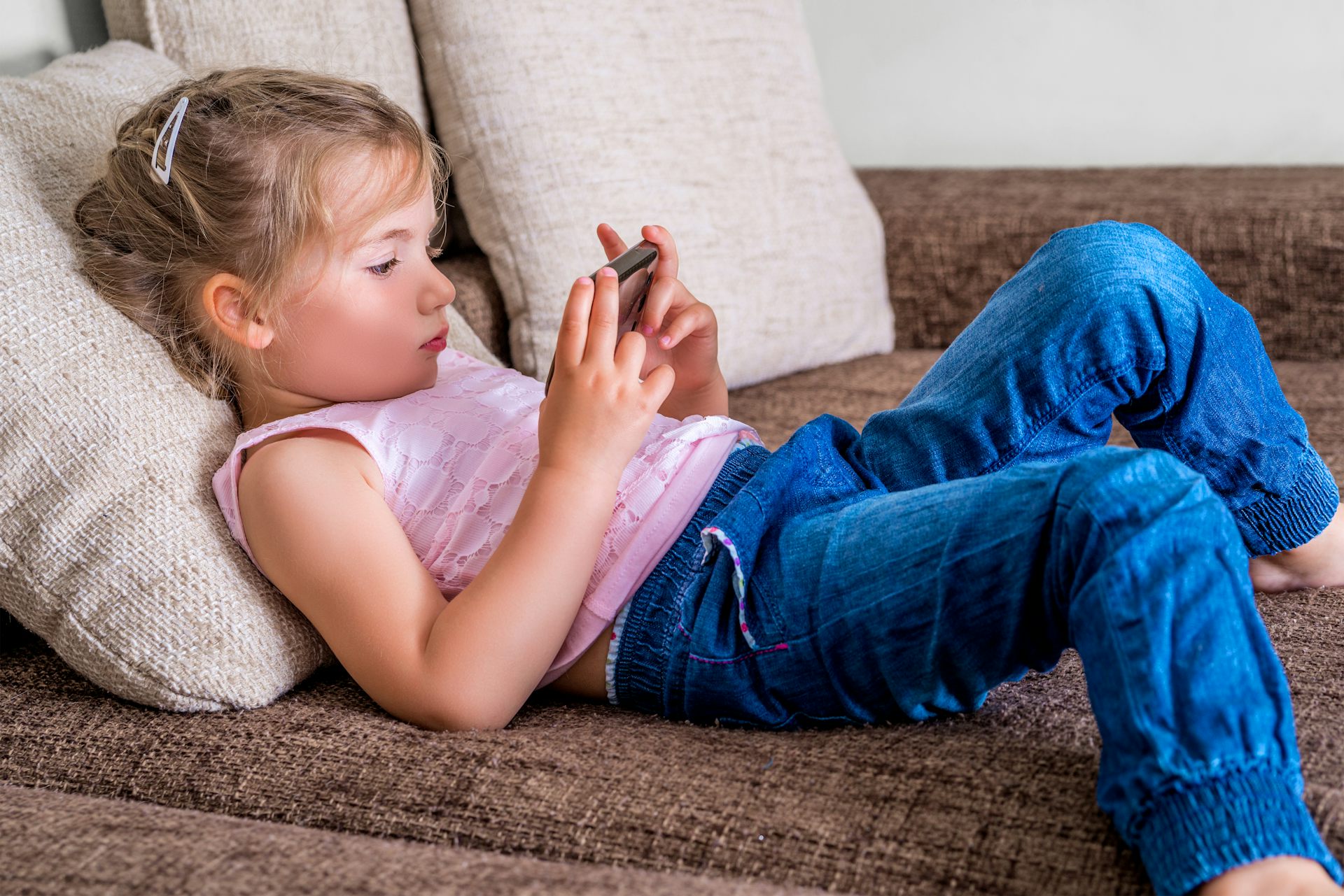 Una niña mira un móvil