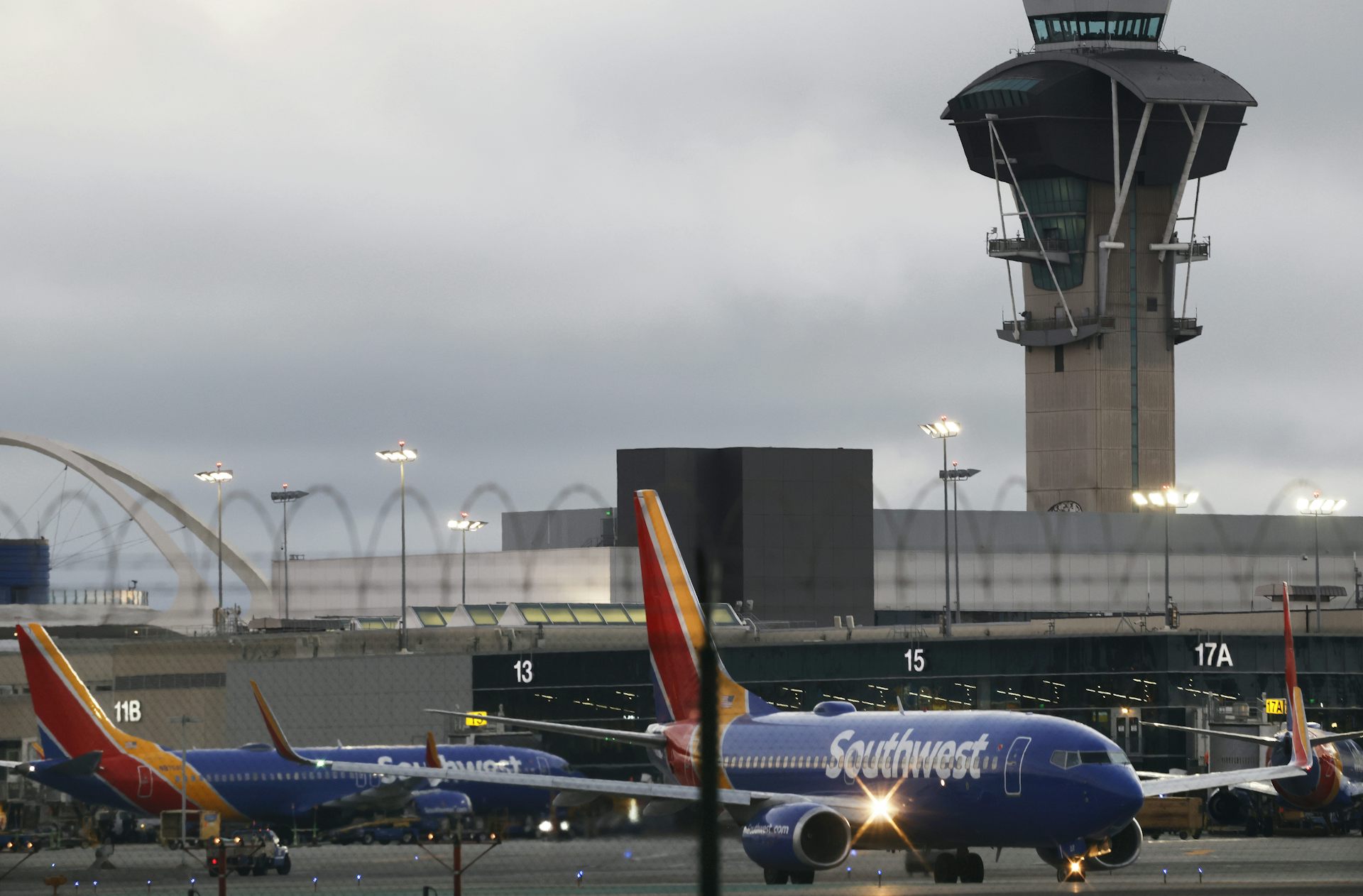 A large building is seen behind a blue plane.