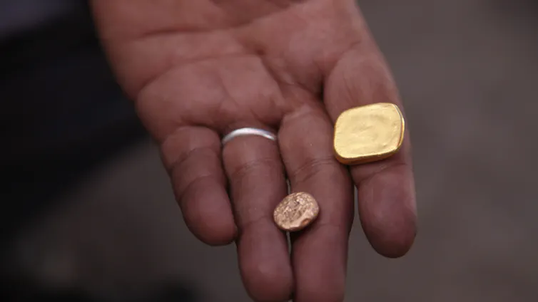 closeup of pieces of gold in a person's hand
