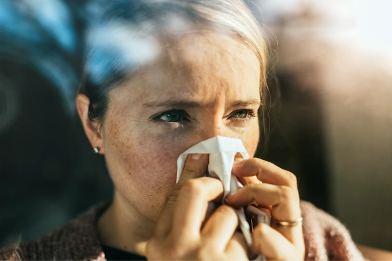 Woman blows her nose
