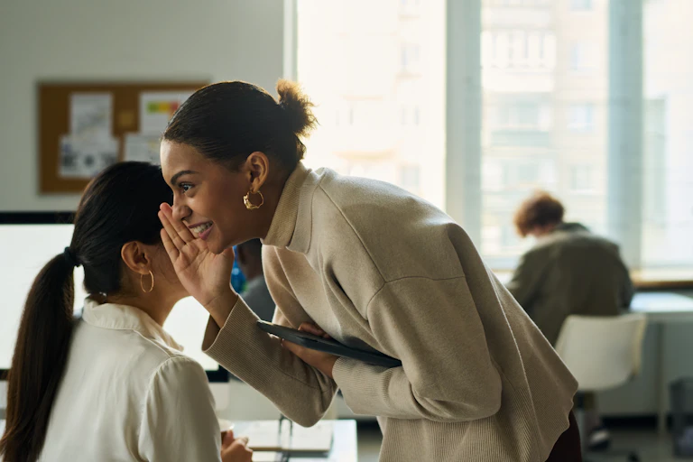 Office workers whispering to each other