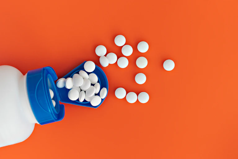 White pills spilling out of a bottle.