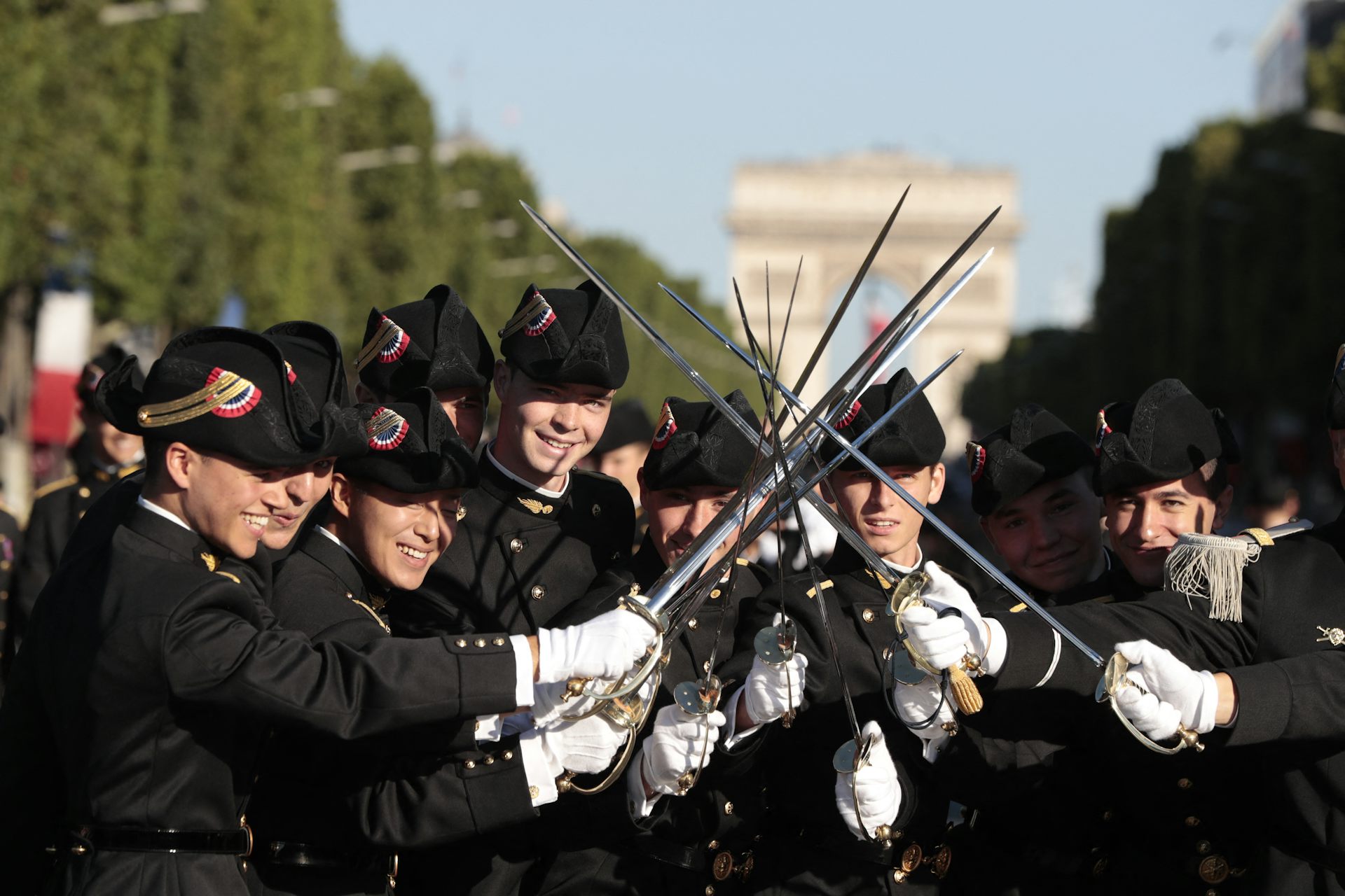 Les élèves de l'École polytechnique, promotion X2016, brandissent leurs épées en attendant le début du défilé militaire annuel du 14 juillet sur les Champs-Élysées à Paris, le 14 juillet 2017