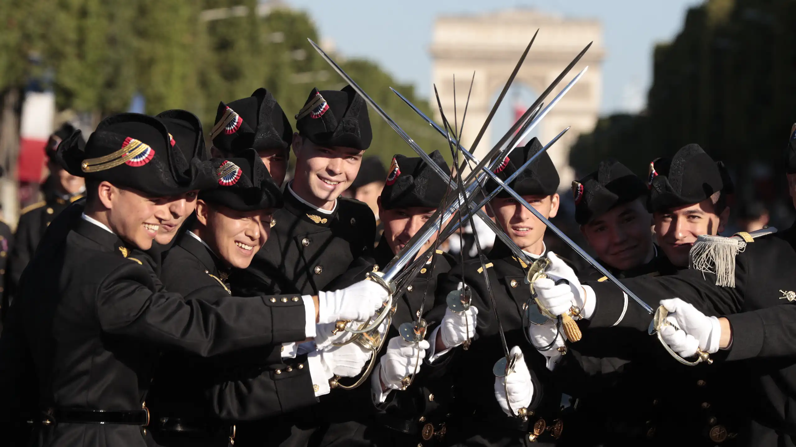 Les élèves de l'École polytechnique, promotion X2016, brandissent leurs épées en attendant le début du défilé militaire annuel du 14 juillet sur les Champs-Élysées à Paris, le 14 juillet 2017