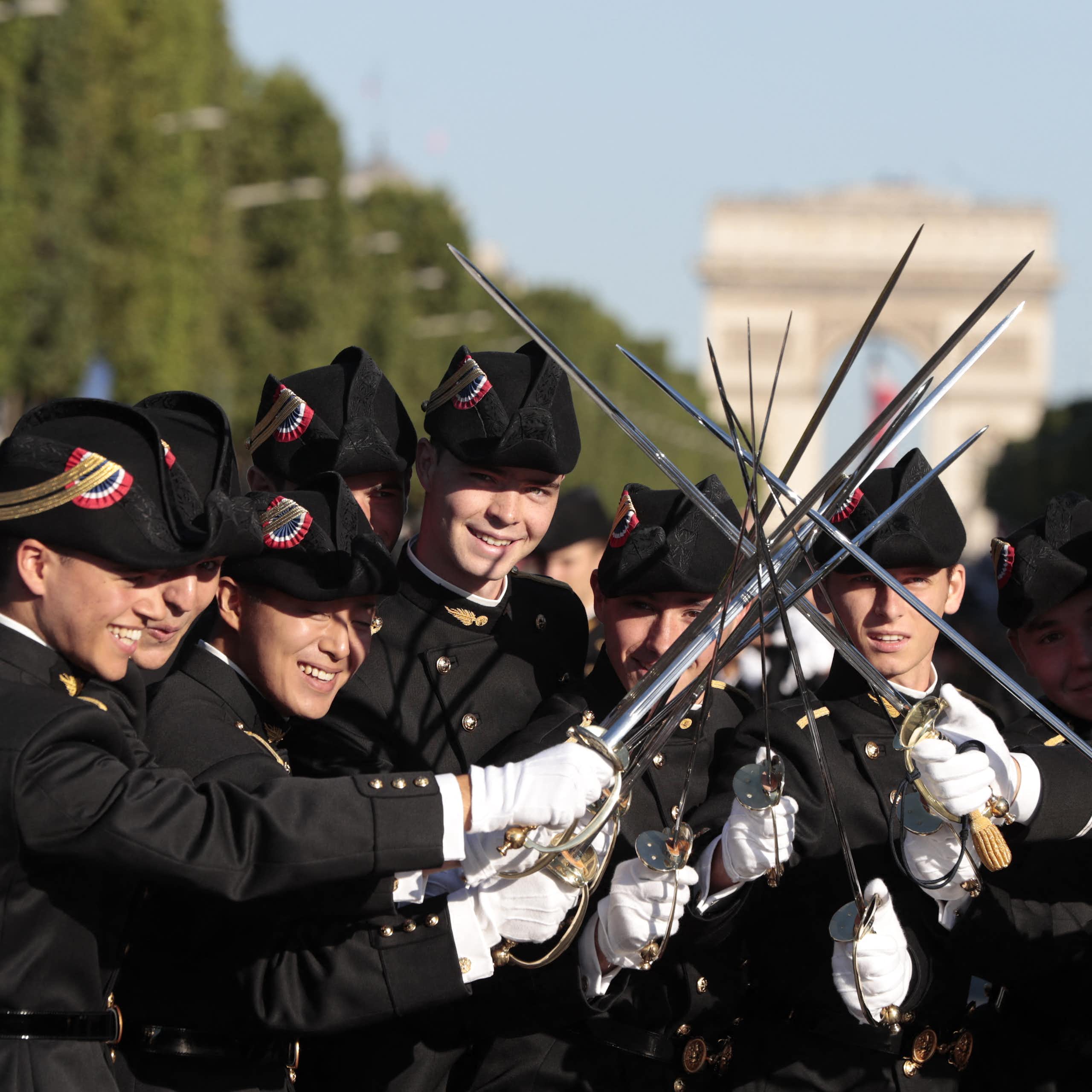 Les élèves de l'École polytechnique, promotion X2016, brandissent leurs épées en attendant le début du défilé militaire annuel du 14 juillet sur les Champs-Élysées à Paris, le 14 juillet 2017