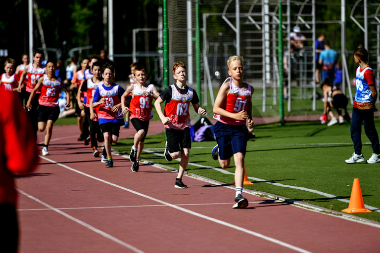 enfant courant sur une piste d'athlétisme