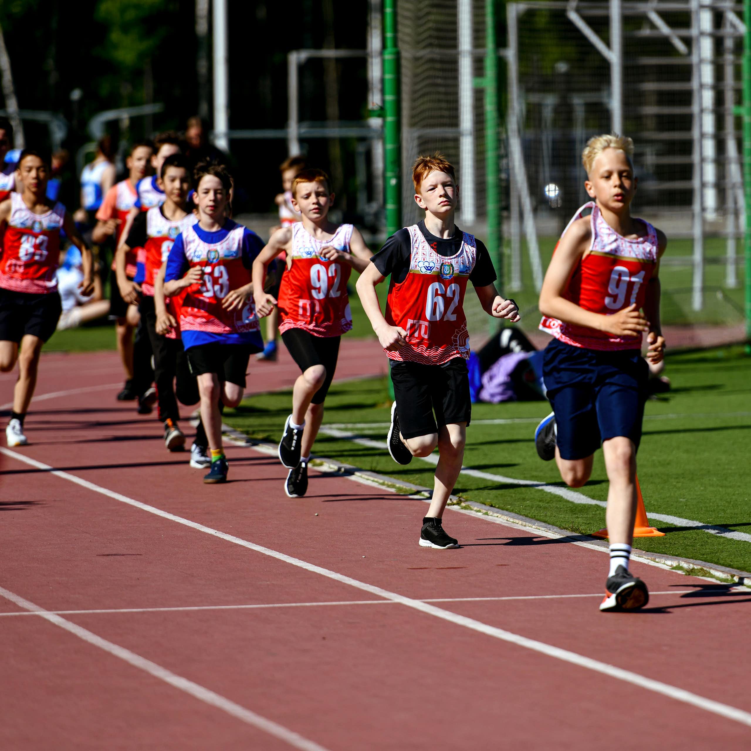 enfant courant sur une piste d'athlétisme