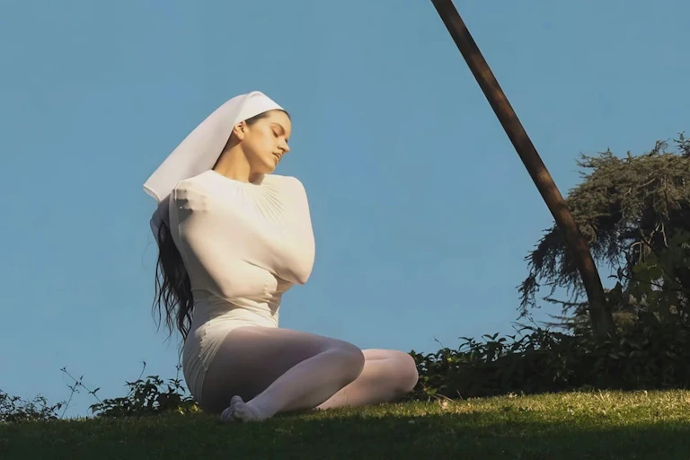 Rosalía in a costume that looks like a couture interpretation of a nun's habit