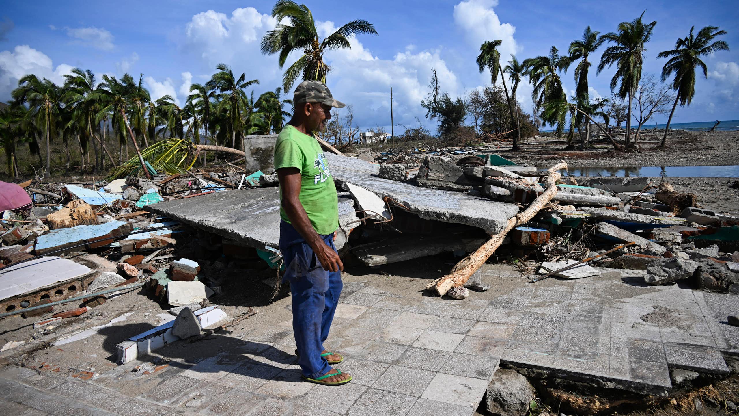 A man stands on land that has been devastated by Hurricane Melissa.