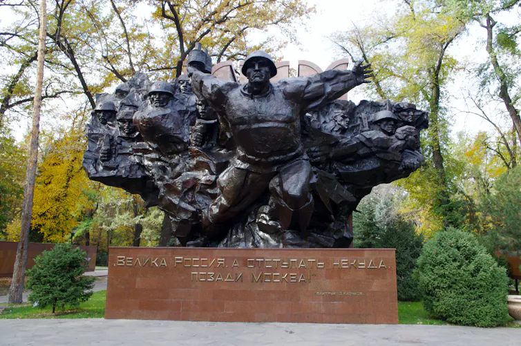 Escultura de bronce que representa a soldados en un parque.