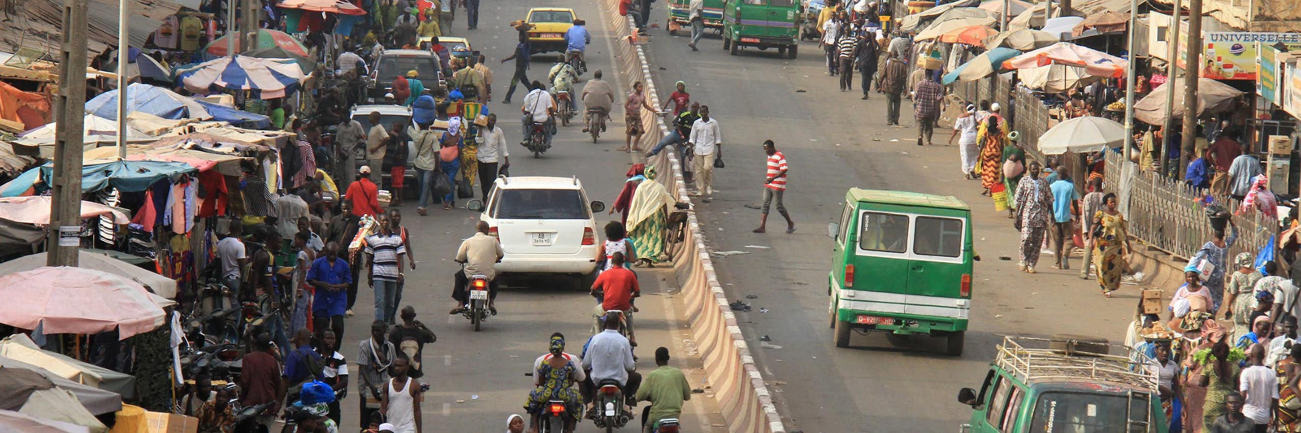 People and cars move along a busy roadway