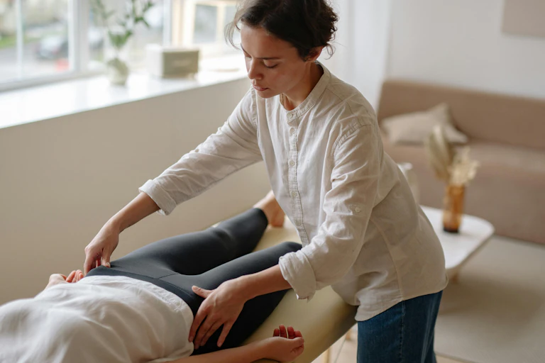 A woman gets her hips checked by a physio.