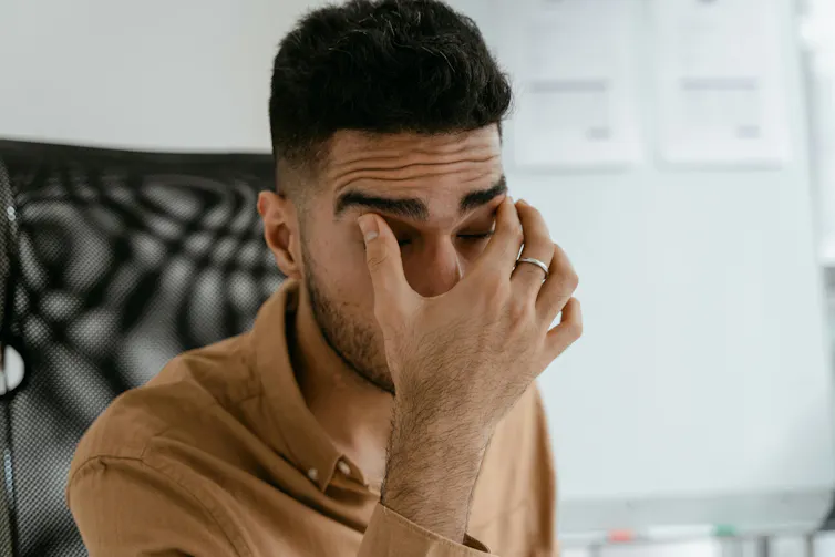 Man rubs his itchy eyes
