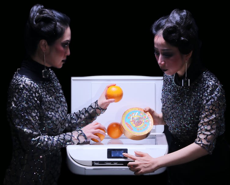 Two women scan oranges and a tin.