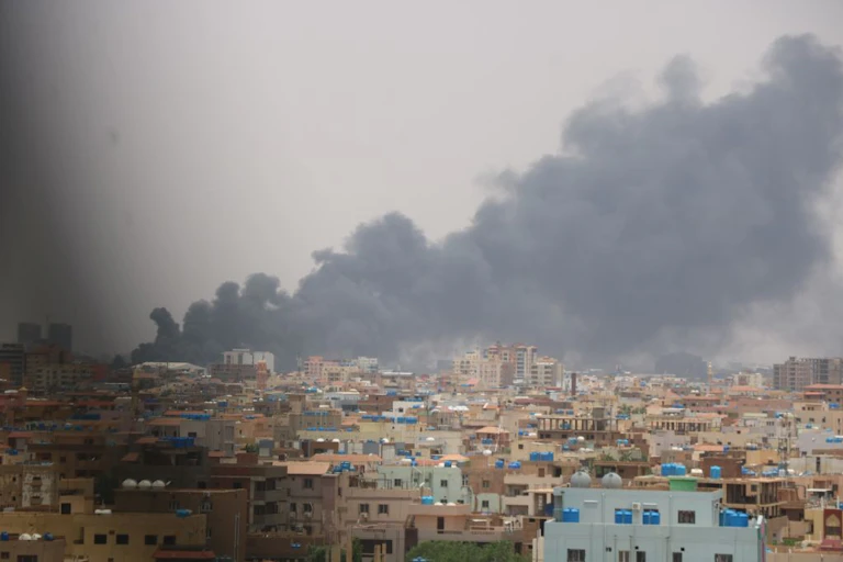 Dark smoke billowing over cityscape