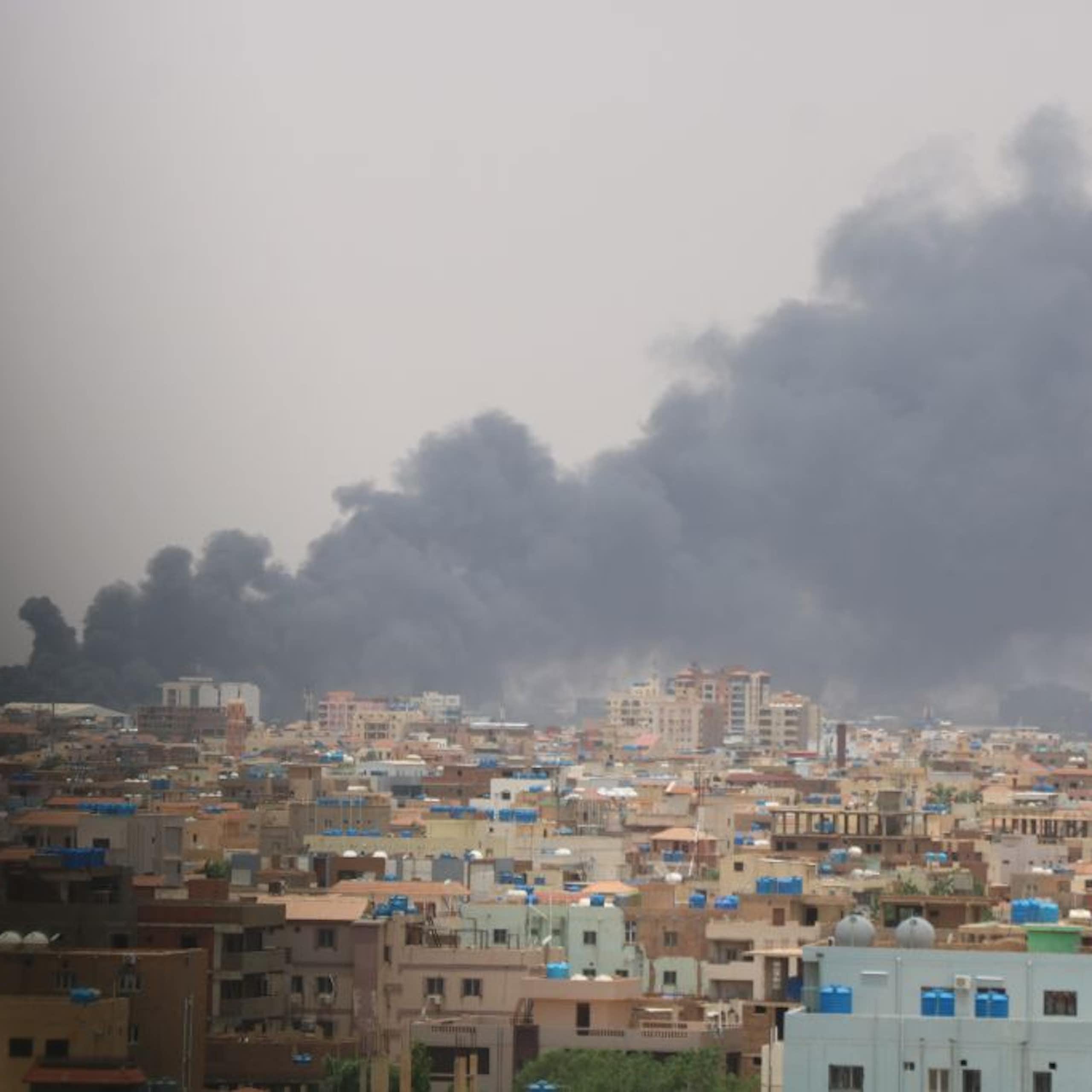 Dark smoke billowing over cityscape