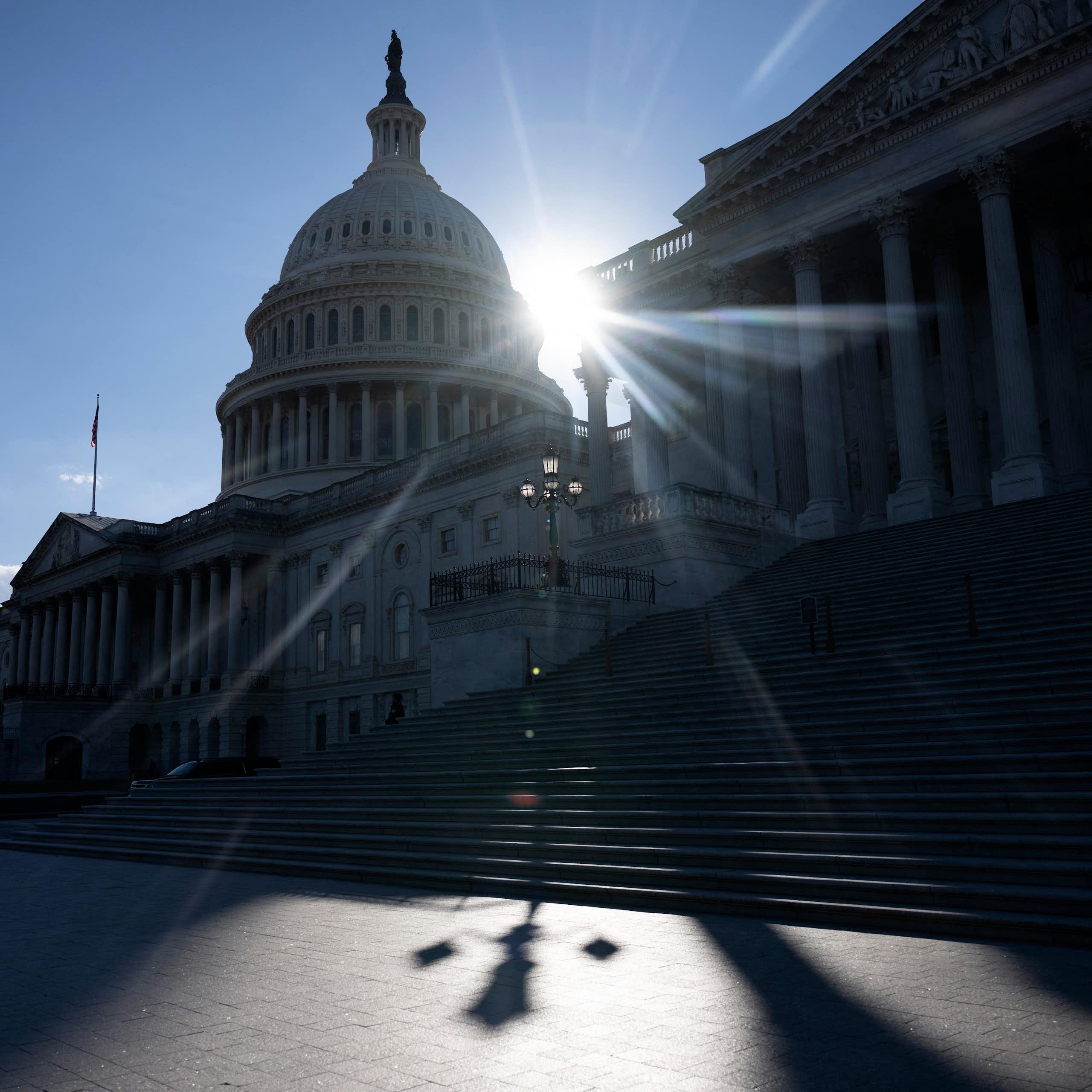 The outline of a dome is seen with the sun behind it.