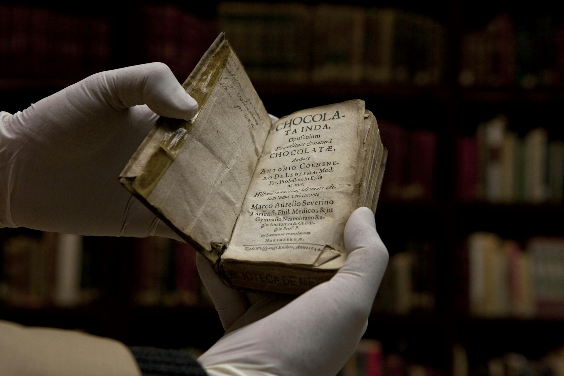 A library worker holds a rare book.