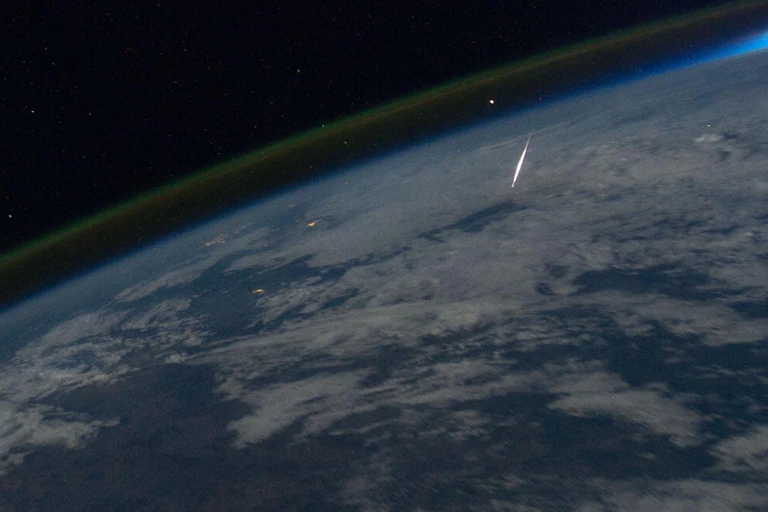 Photo from space showing a meteor falling through Earth's atmosphere