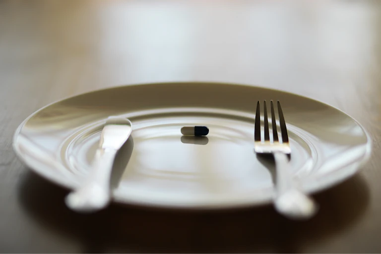 A single pill on a plate.