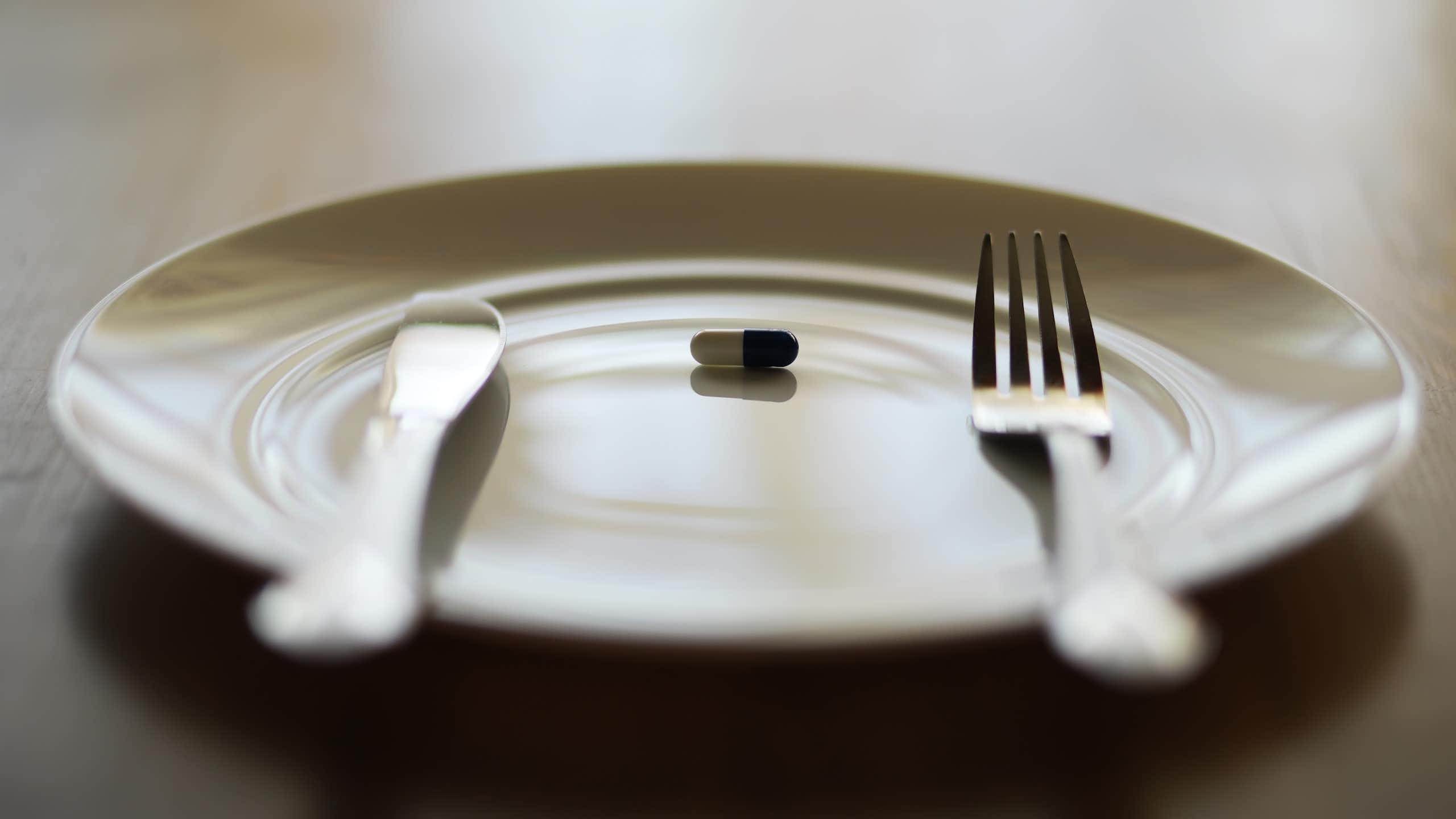 A single pill on a plate.