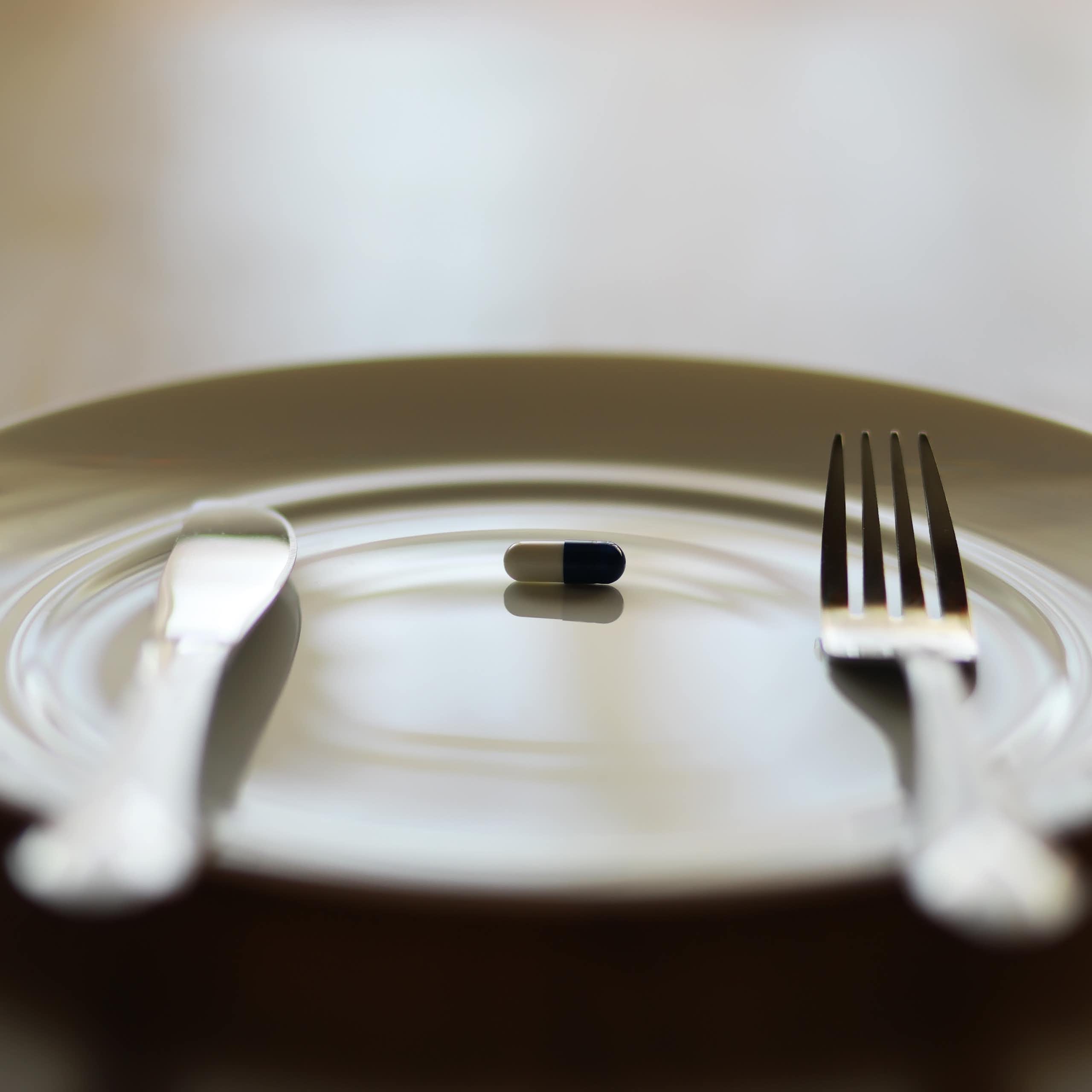 A single pill on a plate.