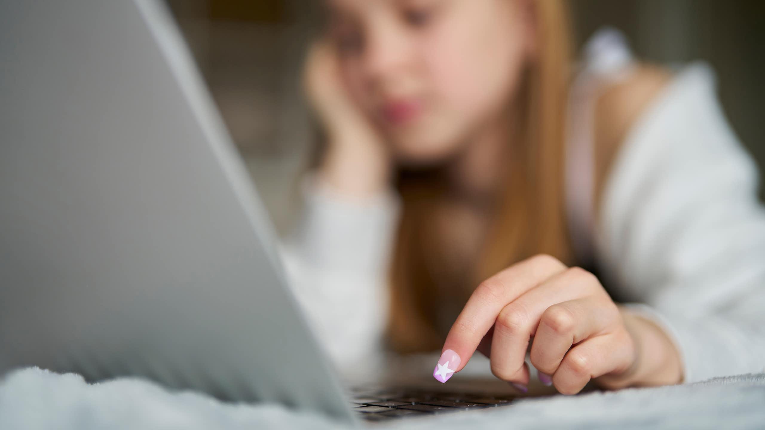 Une jeune adolescente devant un écran d'ordinateur.