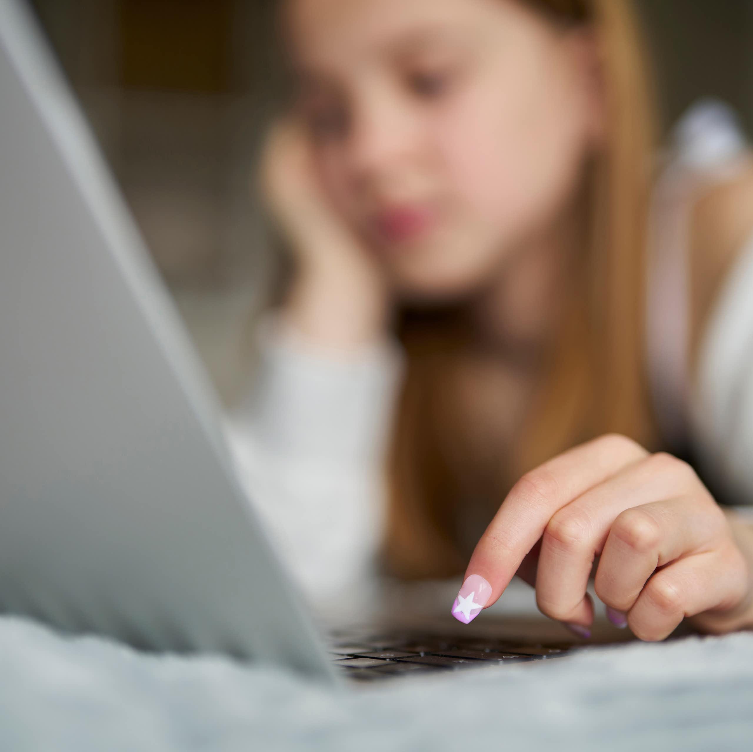 Une jeune adolescente devant un écran d'ordinateur.