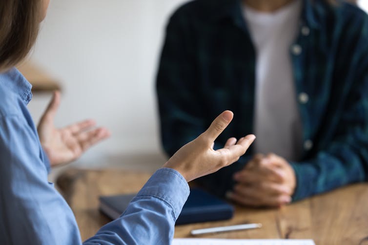 Imagine of two pairs of hands of people in a meeting.