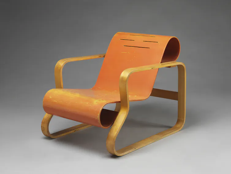 An orange plywood lounging chair.