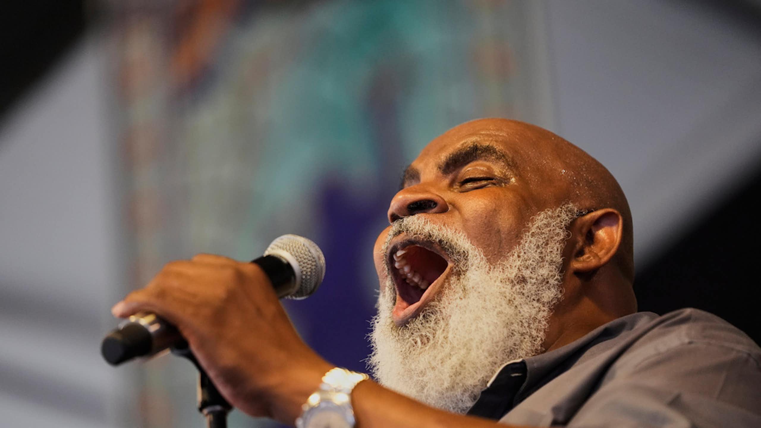 A man sings in a microphone.