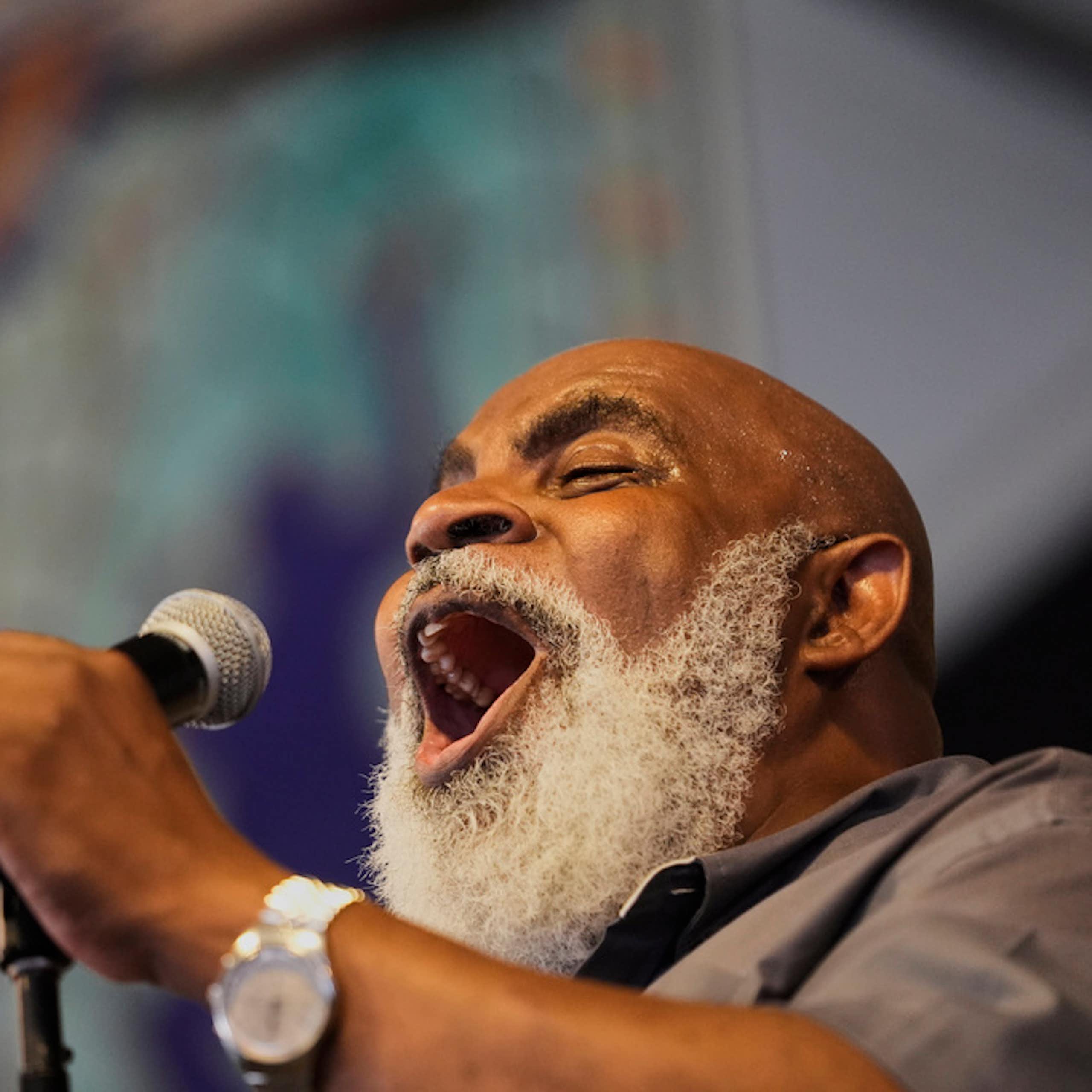 A man sings in a microphone.