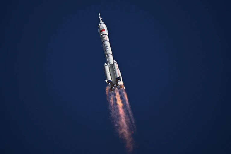 A rocket cruising upward through the atmosphere.