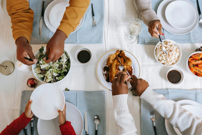 View from above of people's hands and food on a table