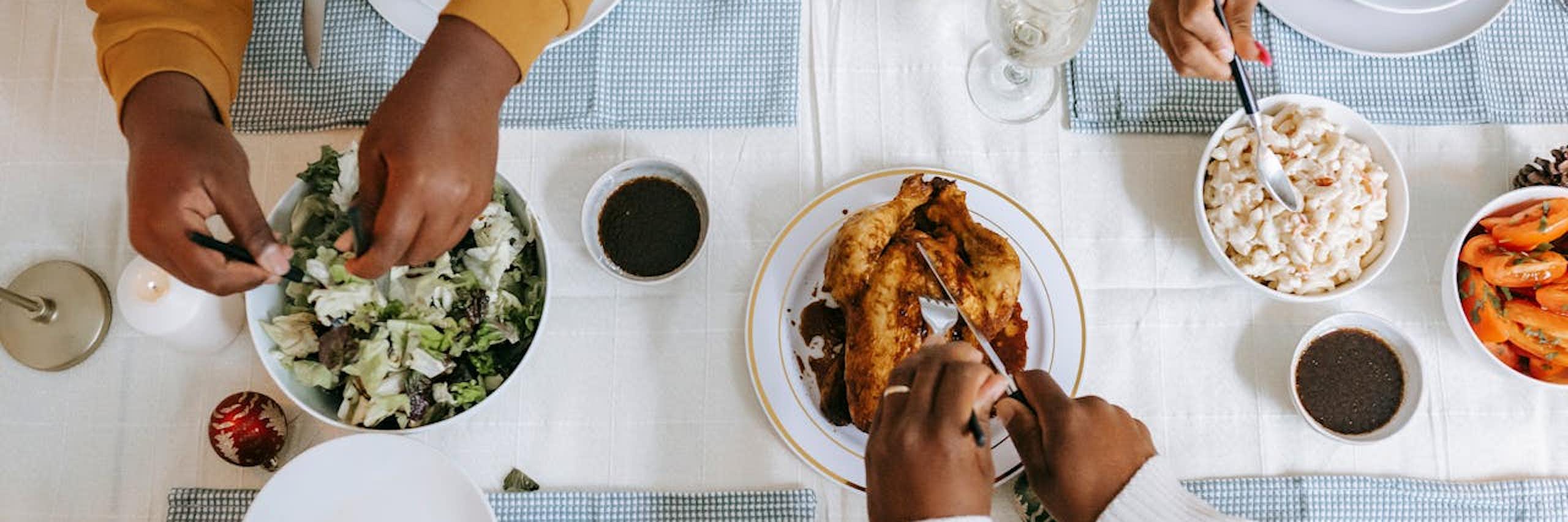 View from above of people's hands and food on a table