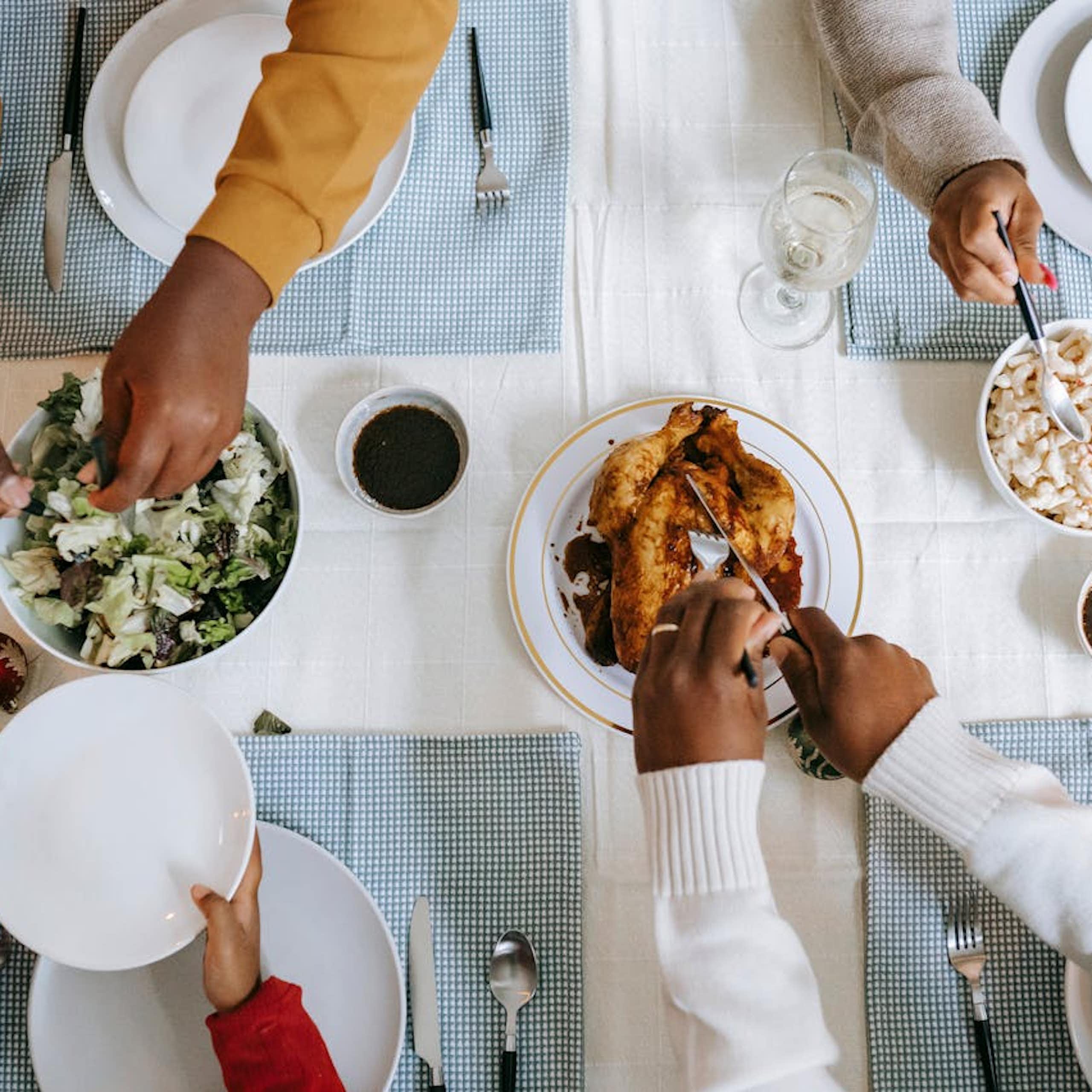 View from above of people's hands and food on a table