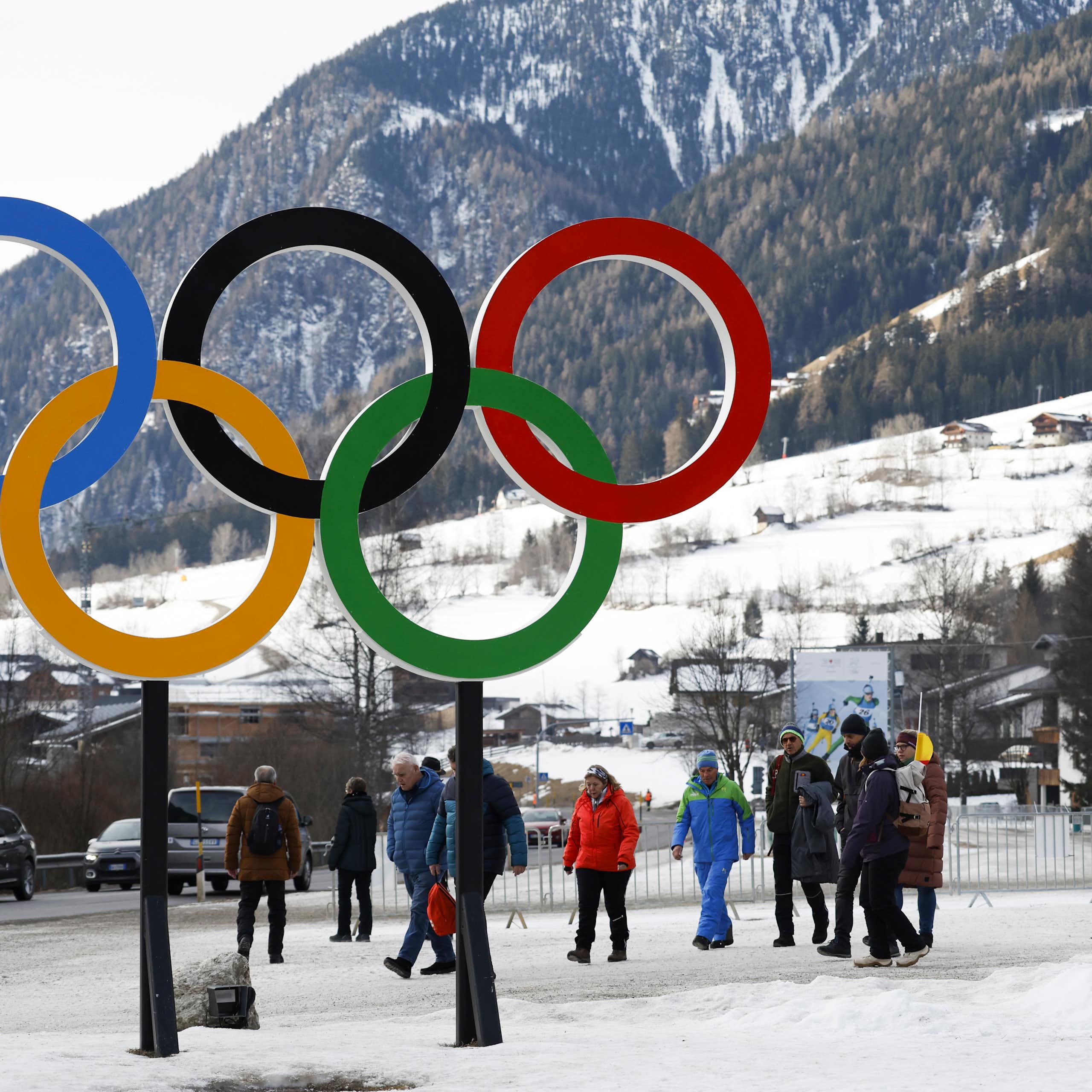 Des personnes marchent près des anneaux olympiques
