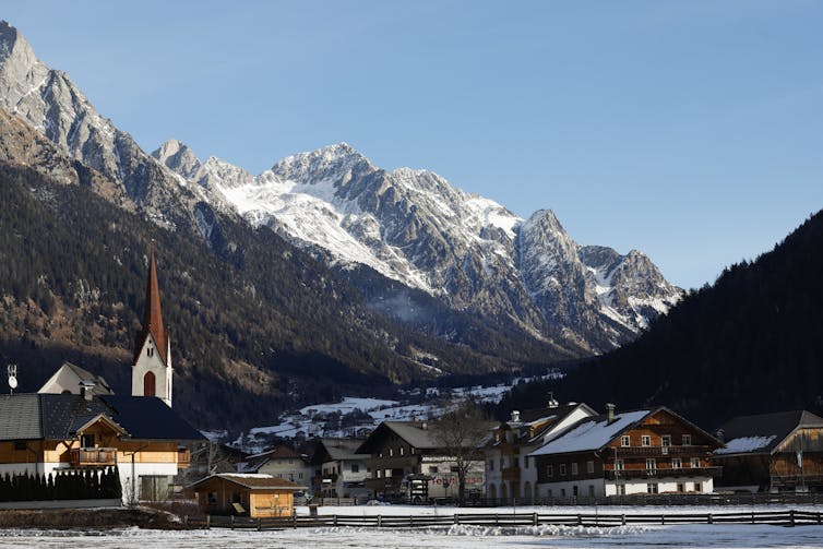 Village surrounded by snow-capped mountains