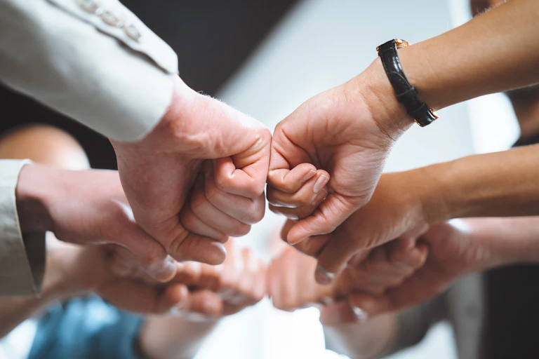 several hands fist-bumping.