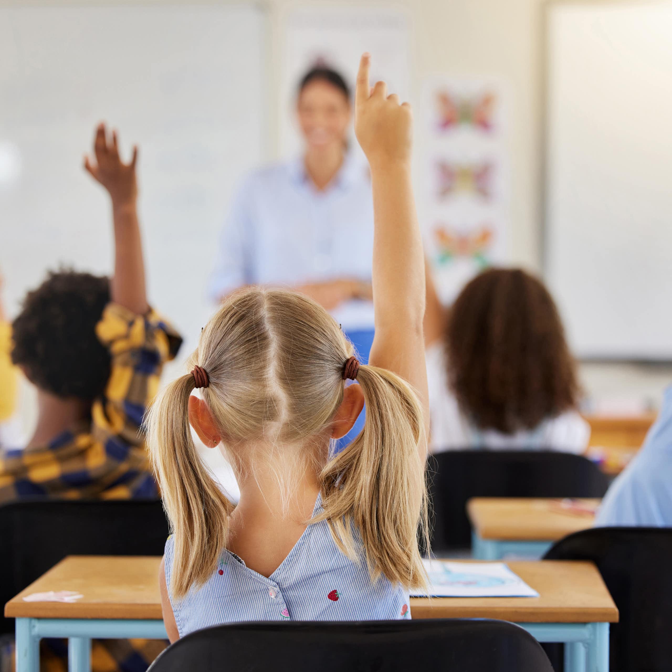 Niños levantando la mano en clase.