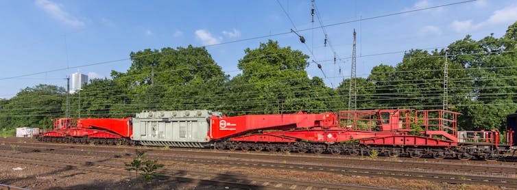 Provide-chain delays, emerging apparatus costs threaten electrical energy grid 1 A massive railcar carries a large metal box.