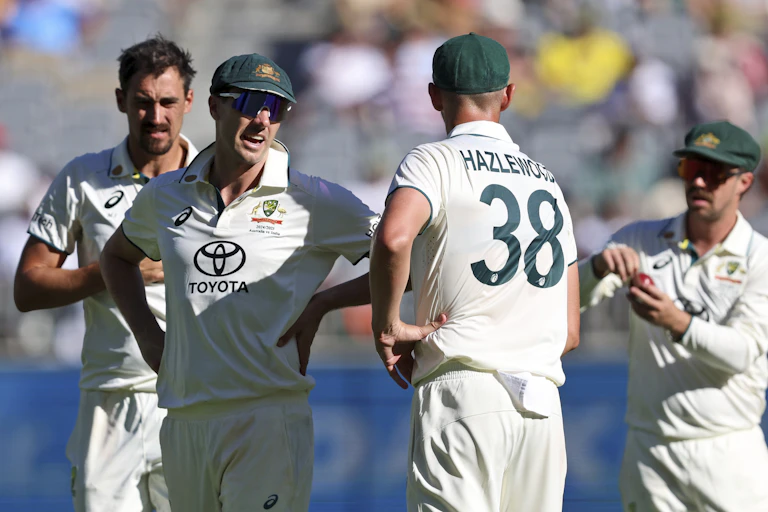 Pat Cummins speaks with Josh Hazlewood during a Test match for Australia.