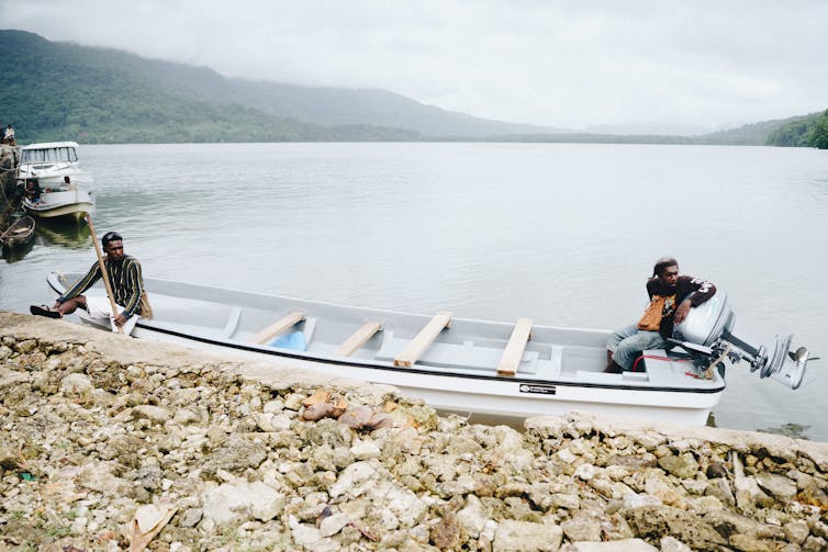 banana boat in harbour with two men.