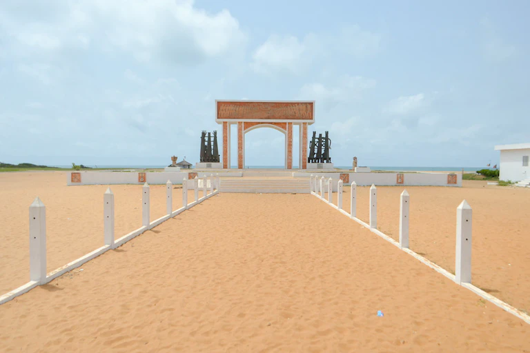 A sandy path leading to an arch