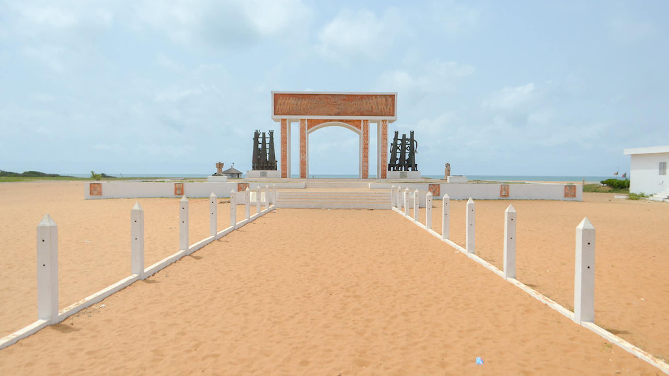 A sandy path leading to an arch