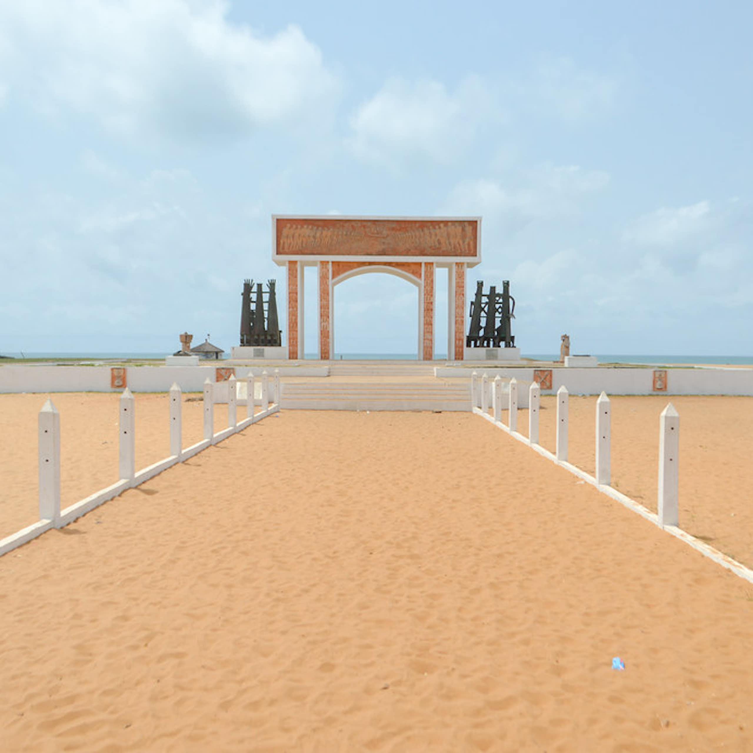 A sandy path leading to an arch