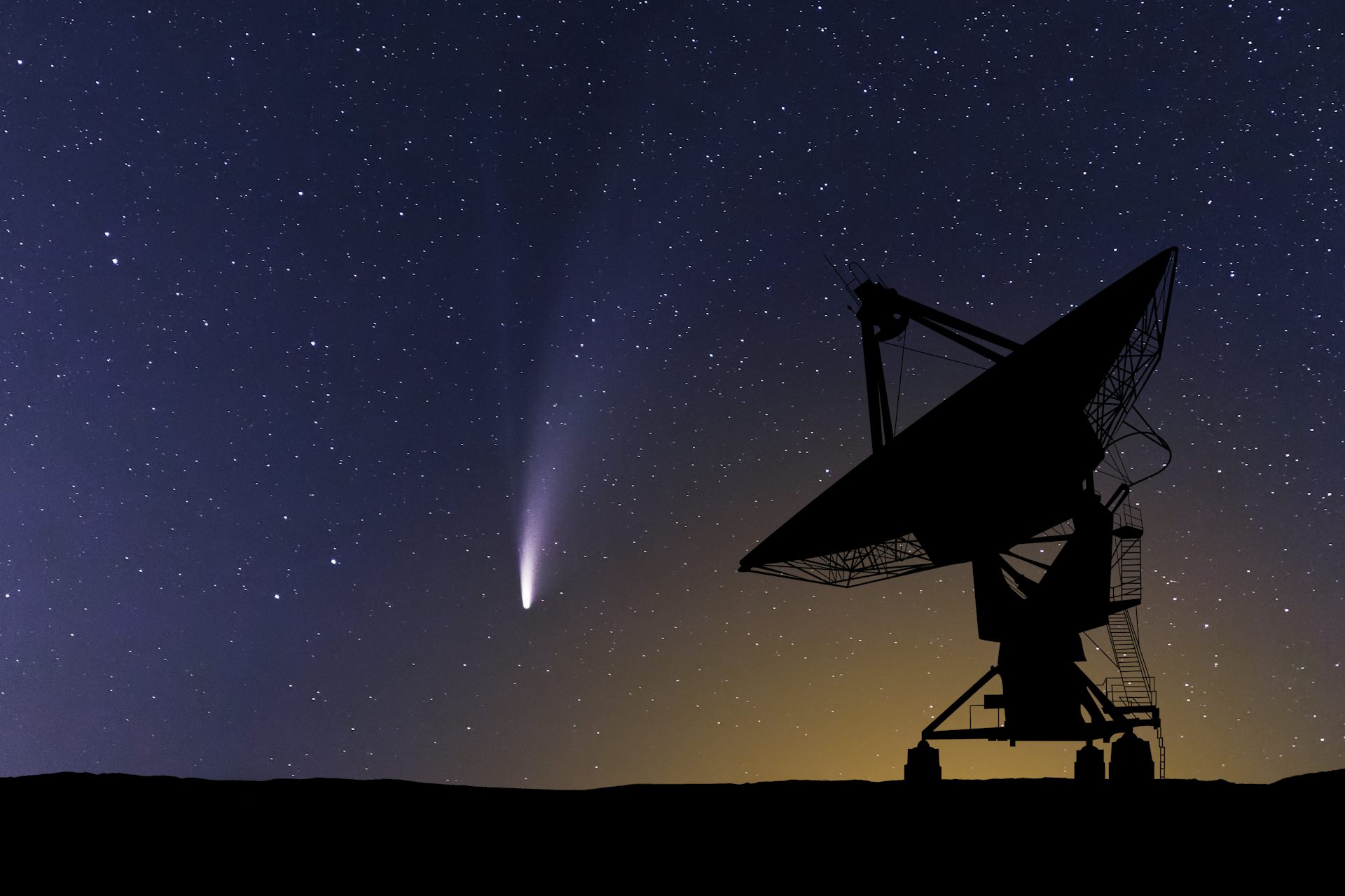 A giant telescope positioned outside looking at the night sky while a comet streaks through